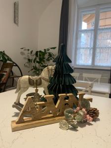 a wooden sign that says new next to a christmas tree at Forst-Ház Apartman in Eger