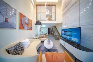 a living room with a couch and a flat screen tv at Millenia Executive Apartment - Guangzhou East Railway Station Zhujiang New Town Branch in Guangzhou