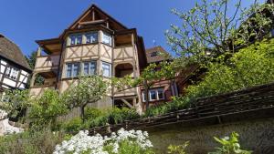 uma casa velha no lado de uma colina em Remparts de Riquewihr - La Cigogne Blanche em Riquewihr