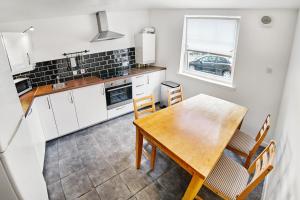 cocina y comedor con mesa de madera y sillas en Thistle Apartments - King's Apartment, en Aberdeen