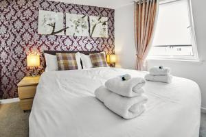 a bedroom with a bed with towels on it at Thistle Apartments - King's Apartment in Aberdeen