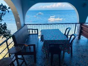 a table and chairs on a balcony with the ocean at SEASCAPE in Moalboal