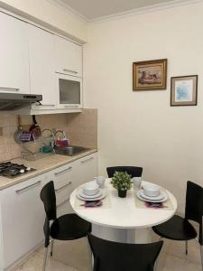 eine Küche mit einem weißen Tisch mit Stühlen und einer Theke in der Unterkunft 2 bedroom next to Mall Central Park & Neo Soho (Medit 1) in Jakarta
