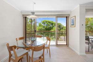 a dining room with a glass table and chairs at Kings View in Peregian Beach