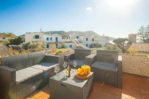 a patio with chairs and a table with wine glasses at Isolella in Campese