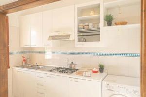 a kitchen with white cabinets and a sink at Isolella in Campese