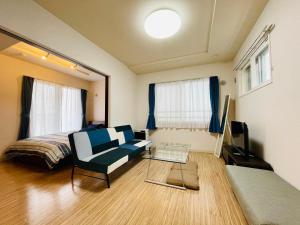 札幌市にある3-3札幌駅徒歩8分　美室【サービスアパートメントSAPPORO札幌駅西】エアコン完備のベッドとソファと椅子のある寝室
