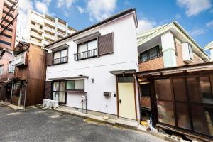 a white building on the side of a street at 【天神HOUSE 】一軒家まるまる貸切 in Fukuoka