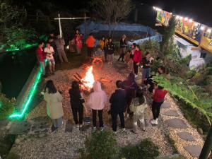 a group of people standing around a fire at night at Peace Home in Sa Pa +160 photos