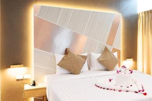 a hotel room with a white bed with a flower decoration on it at La Vista Patong Hotel in Patong Beach