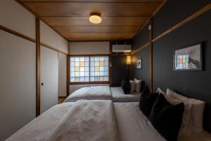 1 dormitorio con 2 camas blancas en una habitación en 【天神HOUSE 】一軒家まるまる貸切, en Fukuoka
