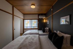 a bedroom with two white beds in a room at 【天神HOUSE 】一軒家まるまる貸切 in Fukuoka