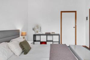 a white bedroom with a bed and a dresser at Nature's Edge - A Parkland Escape for Families in Adelaide +28 photos
