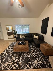 Sundance Retreat في Fort Mohave: غرفة معيشة مع أريكة سوداء وطاولة