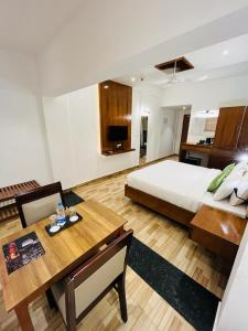 - une grande chambre avec un lit et une table à manger dans l'établissement Queens Tourist Home, à Badagara