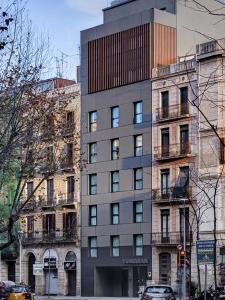 un edificio alto en una calle de la ciudad con edificios en Yurbban Trafalgar Hotel en Barcelona
