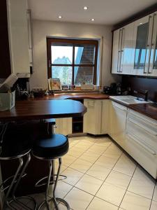Cozy&spacious topfloor apartment في شفايغ بآي نورنبيرغ: مطبخ مع كونتر ومقعد فيه