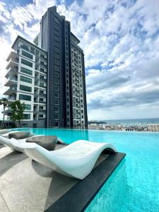 a pool with three white boats in front of a building at Millennium Tower in Pattaya South