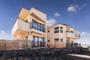 a house on the beach with a stone wall at Geumdanyoung Pension in Jeju