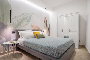 - une chambre avec un lit et un mur blanc dans l'établissement Open Sicily Homes "Residence ai Quattro Canti" - Self check in - Deposito Bagagli, à Palerme