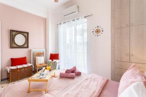 ein Schlafzimmer mit einem rosa Bett und einem Tisch in der Unterkunft Sofi's Flat in the city center, 5min to the sea in Kalamata