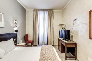 una camera d'albergo con letto e scrivania di Hotel Family House a Roma