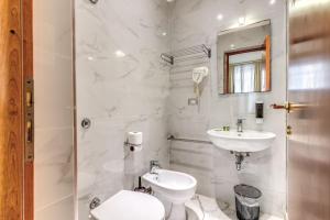 La salle de bains blanche est pourvue de toilettes et d'un lavabo. dans l'établissement Hotel Family House, à Rome