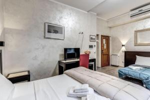 a bedroom with two beds and a desk with a television at Hotel Family House in Rome