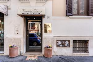 uma loja com uma porta e dois vasos de flores na frente em Hotel Family House em Roma