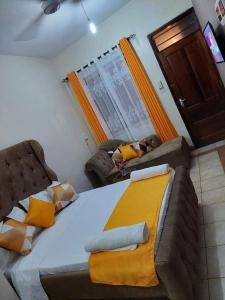 Experience Euphoria, Gish Apartments في مومباسا: غرفة نوم بها سرير كبير وأريكة