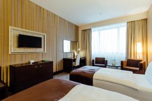 日利納的住宿－吉利納假日酒店，酒店客房设有两张床和一台平面电视。