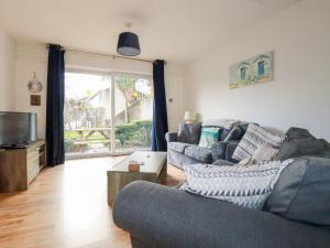 a living room with a couch and a tv at Dolphin Villa in Newquay