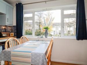 a kitchen with a table and two windows at Dolphin Villa in Newquay
