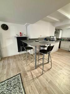 uma cozinha com mesa e cadeiras num quarto em Appartement hyper centre em Rodez