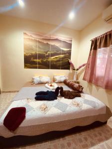 1 dormitorio con 1 cama con una pintura en la pared en Landscape beachfront bungalow in Rawai en Phuket
