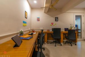 ein Büro mit einem langen Holztisch und Stühlen in der Unterkunft Zostel Bangalore (Koramangala) in Bangalore