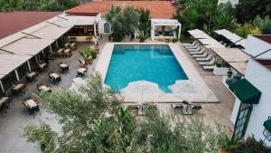 een uitzicht over een zwembad met tafels en stoelen bij Ölüdeniz Blu Luxury Unique Hotel - Adults-Only in Oludeniz