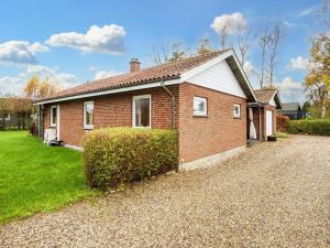 een rood bakstenen huis met een grindoprit bij Holiday home Sydals XCIV in Skovmose