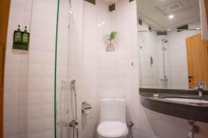 uma casa de banho com um chuveiro, um WC e um lavatório. em LOKAL Rooms x Lahore (Cavalry) em Lahore