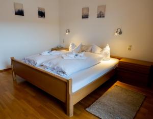 a bedroom with a bed with white sheets and pillows at FeWo Viola 1 OG in Mittenwald
