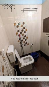 a bathroom with a white toilet in a room at HostelExp, Gokarna - A Slow-Paced Backpackers Community in Gokarna