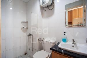 a bathroom with a shower and a toilet and a sink at RedLiving Apartemen Patra Land Urbano - Iconic Room Tower Mid-West in Bulanbulan +13 photos