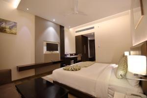 a hotel room with a bed and a television at Enrise by Sayaji Rewa in Rewa