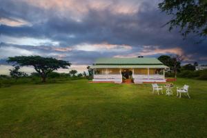 una casa con dos sillas y una mesa en un campo en Wild Pastures by Nature Stays, en Masinagudi