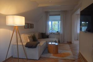 een woonkamer met een bank en een lamp bij Ferienhaus Heimathafen in Friedrichskoog-Spitz