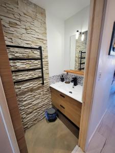 La salle de bains est pourvue d'un lavabo et d'un mur en pierre. dans l'établissement Studio cabine vue port, au Grau-du-Roi