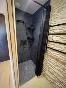 La salle de bains est pourvue d'une douche et d'un mur en pierre. dans l'établissement Studio cabine vue port, au Grau-du-Roi