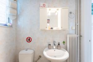 a bathroom with a sink and a toilet and a mirror at Sofi's Flat in the city center, 5min to the sea in Kalamata +27 photos
