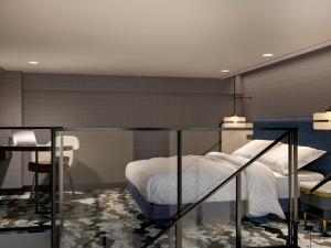 泗水Mercure Surabaya Manyar的一间卧室，配有一张床、一张桌子和几把椅子 更多37张照片