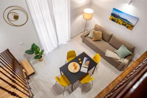 a living room with a table and yellow chairs at Open Sicily Homes - Near the Central Train Station in Palermo